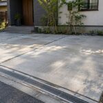 朝の光で目地と排水溝が見える住宅のコンクリート駐車場